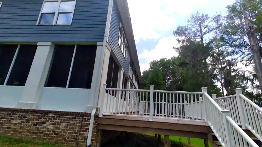 Two story house with brick, siding and a white deck after exterior cleaning